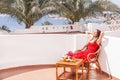 Resting woman is sitting and dreamingin a chair at the terrace.