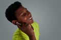 Portrait of a happy teenage african boy wearing wireless earphones and smiling, keeping eyes closed while listening Royalty Free Stock Photo