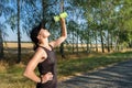 Resting young woman pouring water from bottle on her face after hard workout Royalty Free Stock Photo