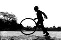 A restless boy is playing on the village road with old discarded tires at Savar, Dhaka,