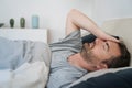 Restless man waking up early with headache after rough night