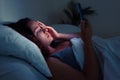 restless night tale: A young woman, besieged by insomnia, finds solace in her phone& x27;s radiant glow.