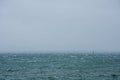 Restless sea and signal light on cold, cloudy, foggy day Royalty Free Stock Photo