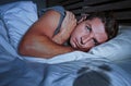 Restless worried young attractive man awake at night lying on bed sleepless having eyes opened depressed suffering insomnia sleepi Royalty Free Stock Photo