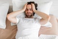 Restless young man waking up with headache Royalty Free Stock Photo