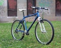 Restomod rebuilt Specialized Stumpjumper 26er mountain bicycle with white handlebars and rigid aluminum fork stands in field. Royalty Free Stock Photo