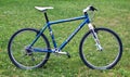 Restomod rebuilt Specialized Stumpjumper 26er mountain bicycle with white handlebars and rigid aluminum fork stands in field. Royalty Free Stock Photo