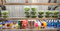 A Stocked Delicatessen Shelf with Greens and Drinks