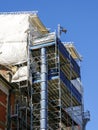 Restoration of the facade of a historic house using scaffolding and construction debris plastic pipe Royalty Free Stock Photo