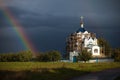 The restoration of the temple against the background of a stormy sky and rainbow