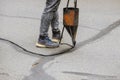 Restoration work sealing cracks applying liquid sealer to asphalt a road protective coat on roadway