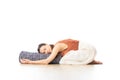 Restorative yoga with a bolster. Young sporty attractive woman in bright white yoga studio, lying on bolster cushion