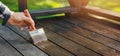 Restore wooden terrace planks. applying wood protection oil on decking boards with paint brush. copy space