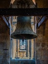 Restored bronze bell but with pigeon poop from the bell tower of the Clerecia church in Salamanca, protected with iron beams and