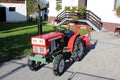 Restored and completely renovated vintage retro old small compact utility tractor with new tyres parked on paved driveway