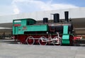 The restored green ancient locomotive with red weels