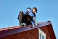 Restoring roof after hurricane, roofer fixes tin sheets torn off by wind on roof