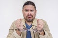 A restrained man sighs and resigns to his fate after being detained and handcuffed. Isolated on a white background