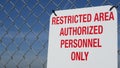Restricted area, authorized personnel only sign in USA. Red letters, keep off warning on metal fence, United States border symbol Royalty Free Stock Photo