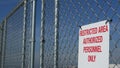 Restricted area, authorized personnel only sign in USA. Red letters, keep off warning on metal fence, United States border symbol Royalty Free Stock Photo