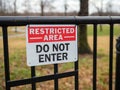 Restricted area do not enter sign hung on black gate