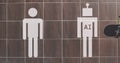 Restroom signs depict a human and an AI figure on a tiled wall