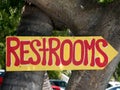 Restrooms sign with an arrow points toward a nature trail that leads to the bathroom