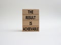 The result is achievable symbol. Concept words The result is achievable on wooden blocks. Beautiful white background. Business and Royalty Free Stock Photo
