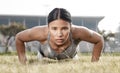 Results happen overtime not over night. Shot of a beautiful young woman doing push-ups outside. Royalty Free Stock Photo