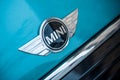 Retail of Austin mini cooper logo on blue car parked in the street