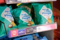 Retail bags of flavoured crisps seen on a display shelf at a popular, UK bakers and food outlet. The display is near the entrance