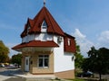 Small house on street corner with pointy red clay roof