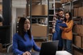 Retail storehouse employees checking clipboard with orders list