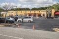 Retail strip mall Cars lined up outdoor curb event security officer social distancing