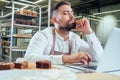 Retail trade concept , man owner of food factory using devices for online business order at bakehouse Royalty Free Stock Photo