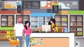 Retail woman cashier at checkout supermarket couple customers holding basket with food shopping concept grocery market