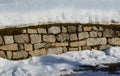 Retaining wall made of granite bricks by the road. the snow fit all around, only the wall remained visible in its beautiful textur