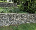 retaining wall made of smooth round stones in landscape design Royalty Free Stock Photo