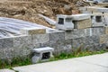 Retaining wall project in a residential house build, sidewalk, blocks, plastic, and dirt, work in progress