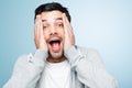 Retarded man making funny faces is silly. a young man looking shocked against a studio background.