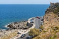 Curvy road with parked cars along the coastline of Mediterranean sea at Crete island