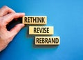 Rethink revise rebrand symbol. Concept word Rethink Revise Rebrand on beautiful block. Beautiful blue table blue background.