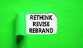 Rethink revise rebrand symbol. Concept word Rethink Revise Rebrand on beautiful white paper. Beautiful green table background.