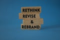 Rethink revise rebrand symbol. Concept word Rethink Revise and Rebrand on brick blocks. Beautiful blue background. Business brand