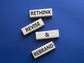 Rethink Revise and Rebrand symbol. Wooden blocks with words Rethink Revise and Rebrand. Beautiful deep blue background. Business