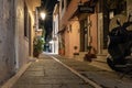 Night narrow street of old town center, decorated with flower pots. Royalty Free Stock Photo