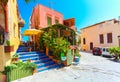 Rethymnon, Island Crete, Greece, - July 1, 2016: Cosy cretan small cafe with flowers outside with ad on the green board about