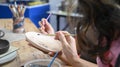 Retire woman painting on her handicraft pottery at workshop. Retirement, leisure activity, handicraft, hobbies concept