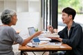 A retired Asian female client discussing her home building design with an architect in the office Royalty Free Stock Photo