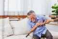 Retired Asian senior elderly husband pain from heart attack disease or illness with serious or worried wife take care at home. Royalty Free Stock Photo